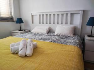 una camera da letto con un letto con due asciugamani sopra di Zambujal Sun a Sesimbra Altre 7 foto