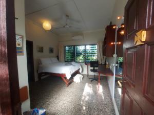 a bedroom with a bed and a desk and a window at Hechtech House in Accra