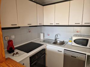 małą kuchnię z białymi szafkami i zlewem w obiekcie Apartamento del Niño w mieście Campoamor