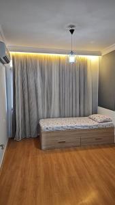 a bedroom with a bed in front of a curtain at apartment 3+1 beach view in Mersin