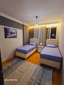 a bedroom with two beds and a rug at apartment 3+1 beach view in Mersin