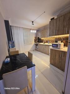 a kitchen with a table and a microwave at apartment 3+1 beach view in Mersin
