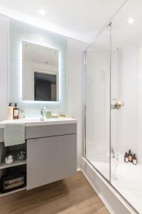 a bathroom with a white sink and a shower at Cosy Ensuites with Shared Kitchen and Living Area at Alma Place in the heart of Belfast in Belfast