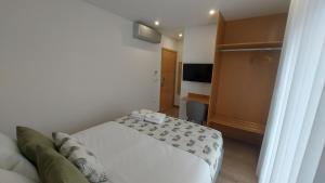 Habitación de hotel con cama y escritorio en DiROMANE en Braga