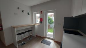 a living room with two stools and a window at DiROMANE in Braga