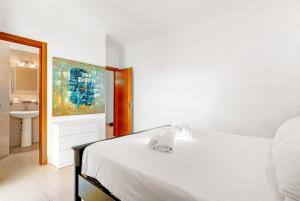 パルム・マールにあるPalm Mar Penthouse Duplexのベッドルーム(白いベッド1台付)、バスルーム
