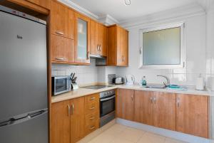 a kitchen with wooden cabinets and a sink and a microwave at Palm Mar Penthouse Duplex in Palm-mar