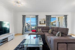 a living room with a couch and a tv at Palm Mar Penthouse Duplex in Palm-mar