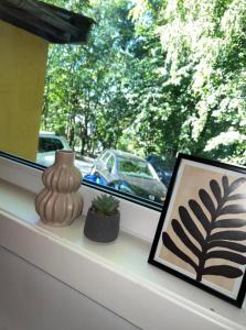 um peitoril de janela com uma imagem e uma planta sobre ele em Liten koselig hybel i Gamle Oslo em Oslo