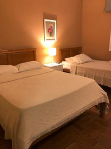 um quarto de hotel com duas camas e um candeeiro em Funchal 19 em Funchal