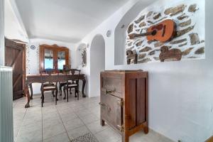 a room with a table and a violin on a wall at Azul Boutique Home in Skiathos
