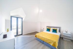 Habitación blanca con cama con colcha amarilla en Pena View Apartment, en Santa Cruz