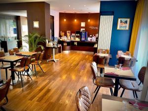 a restaurant with wooden floors and tables and chairs at Kyriad Grenoble Centre in Grenoble