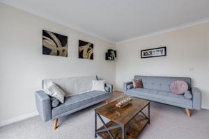 a living room with two couches and a coffee table at 3 Bed House, Sleeps 8 - Contractors, Relocators & Visitors, Parking, Garden, Wi-Fi & Foosball table in Bedford