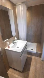 W łazience znajduje się biała umywalka i wanna. w obiekcie La Cigale - Piscine - Centre village w mieście Bessan