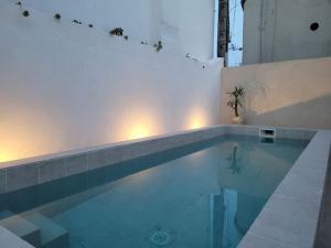a swimming pool in a building with aperature at La Cigale - Piscine - Centre village in Bessan +12 photos