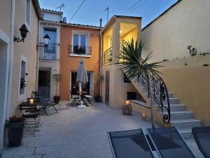 un cortile di un edificio con scala e una casa di La Cigale - Piscine - Centre village a Bessan