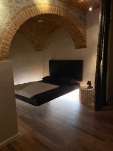 ein Schlafzimmer mit einem Bett in einer Ziegelwand in der Unterkunft Borgo di Bagnolo in Villa Barone