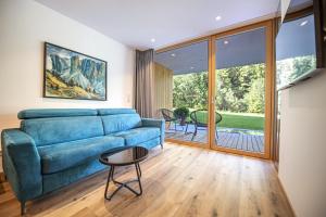 a living room with a blue couch and a table at Greva Apartments 1 in Santa Cristina in Val Gardena