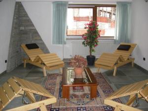 una habitación con bancos, una mesa y un árbol en Hotel Savoia Debili, en Sauze dʼOulx