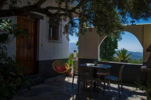 a patio with a table and chairs and a door at Balcón de Válor in Válor