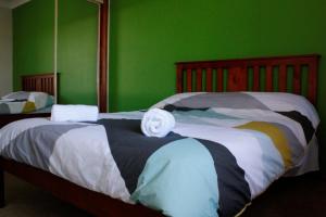 a bedroom with two beds with green walls at Luxury house in heart of Hopeisland in Gold Coast