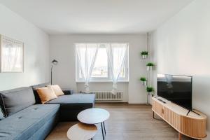 sala de estar con sofá azul y TV en Roseto Apartment by Quokka 360 - apartment in strategic area with balcony, en Balerna