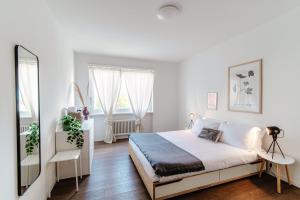 een witte slaapkamer met een groot bed en 2 ramen bij Roseto Apartment by Quokka 360 - apartment in strategic area with balcony in Balerna
