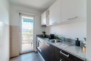 een keuken met een wastafel en een groot raam bij Roseto Apartment by Quokka 360 - apartment in strategic area with balcony in Balerna