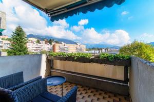 un patio con 2 sillas y una mesa en el balcón en Roseto Apartment by Quokka 360 - apartment in strategic area with balcony, en Balerna