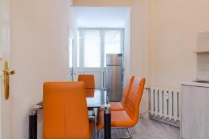 ein Esszimmer mit einem Tisch und orangefarbenen Stühlen in der Unterkunft The Right Choice 2 in Sofia
