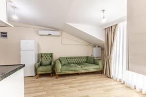uma sala de estar com um sofá verde e duas cadeiras em Flat with Terrace 1 min to Trump Towers em Istambul