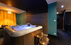 a bathroom with a tub in a room with lights at La Somptueuse 100m2 Spa/Sauna privé in Nancy