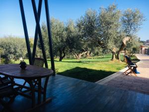a table and chairs on a porch with a view of trees at Villa di Carlone in Moscufo