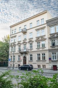 a car parked in front of a large building at Hotel Maximum in Krakow