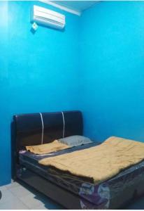 un letto in una camera con parete blu di GASTRO HOMESTAY a Halangan