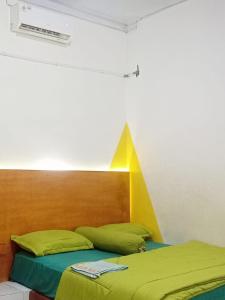 sypialnia z łóżkiem z zagłówkiem i żółtym i zielonym w obiekcie GASTRO HOMESTAY w mieście Halangan