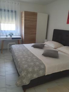um quarto com uma cama grande e uma secretária em Apartmani Zlata em Sveti Filip i Jakov