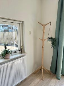 een kamer met een raam en een houten paal met planten bij Amsterdam Beach Apartment 17, incl Parking + Garden in Zandvoort