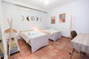 two beds in a room with white walls at Casa espaciosa cerca de Monachil in La Zubia