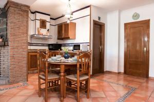 a kitchen with a table and chairs in a room at Casa espaciosa cerca de Monachil in La Zubia