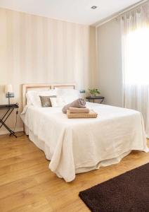 une chambre avec un lit avec des draps blancs et une fenêtre dans l'établissement AG Casa Bértoa con jardín y comedor exterior x8, à Queo de Abaixo
