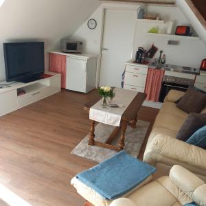 uma sala de estar com um sofá e uma mesa em Zur weißen Rosenblüte, Appartement em Schneverdingen