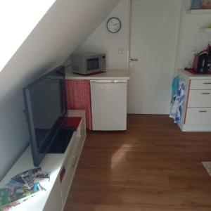 uma pequena cozinha com um micro-ondas e um balcão em Zur weißen Rosenblüte, Appartement em Schneverdingen