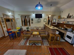 a living room with tables and chairs and a kitchen at Apartman Quince Gradac in Valjevo