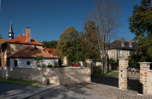 une clôture devant une maison avec une église dans l'établissement Le Clocher de la Duchesse, à Bonnelles