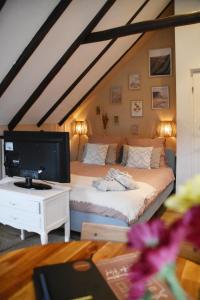 a bedroom with a bed with a tv on a table at Bed en Breakfast Studio Raif - Authentiek en sfeervol overnachten in Veendam