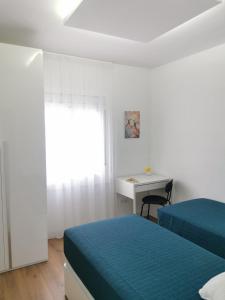 a bedroom with two beds and a desk and a window at Bonito Ático in Terrassa