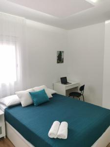 a bedroom with a bed with two towels on it at Bonito Ático in Terrassa