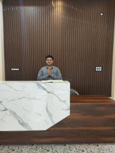 a man is standing behind a marble counter at Hotel Hari Gayatri Regent in Guwahati